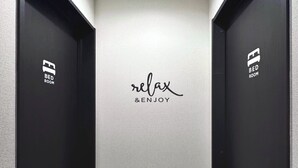 A hallway with two black doors labeled "BED ROOM" and a wall with the text "relax & ENJOY". - NEW! [Built in 2024, Entire Newly Built House for Rent / Free Parking Available] Experience Osaka’s Old Town! Conveniently located just 8 minutes by train from Namba! Excellent access to Osaka, Kyoto, and Nara! (大阪市)