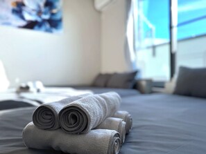 A neatly made bed with rolled towels and a view of the sea through a window. - NEW! [Built in 2024, Entire Newly Built House for Rent / Free Parking Available] Experience Osaka’s Old Town! Conveniently located just 8 minutes by train from Namba! Excellent access to Osaka, Kyoto, and Nara! (大阪市)