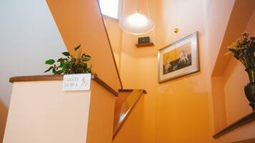 A staircase with a sign indicating a camera room, a framed picture on the wall, and a hanging light fixture.