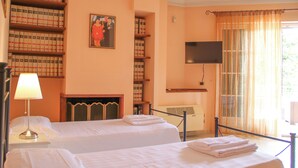 A hotel room with two beds, a bookshelf, a fireplace, a television, and a window with curtains. - Boteroom Relais (Piedimonte San Germano)