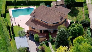 A two-story house with a swimming pool, surrounded by well-maintained gardens and trees. - Boteroom Relais (Piedimonte San Germano)