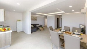 A modern kitchen with a dining area, a sofa, and a small refrigerator. - Apartments Mi&Ni -Comfort Two Bedroom Apartment with Terrace and Sea View (no.3) (Cavtat)