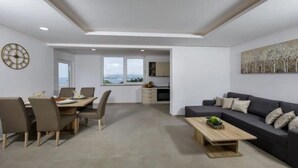 A modern living room with a dining area, a sofa, and a coffee table. - Apartments Mi&Ni -Comfort Two Bedroom Apartment with Terrace and Sea View (no.3) (Cavtat)