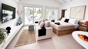 Une chambre moderne avec un grand lit, un canapé et un coin repas.