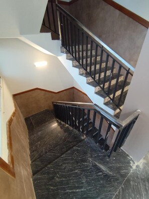Un escalier avec des rampes noires et des marches à motifs.