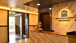 A reception area with a marble counter, a statue, and a sign for Sree Mahalaksmi Residency. - Sree Mahalakshmi Residency (Kariyapatti)