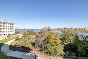 A hotel with a view of a body of water and a city skyline in the distance.