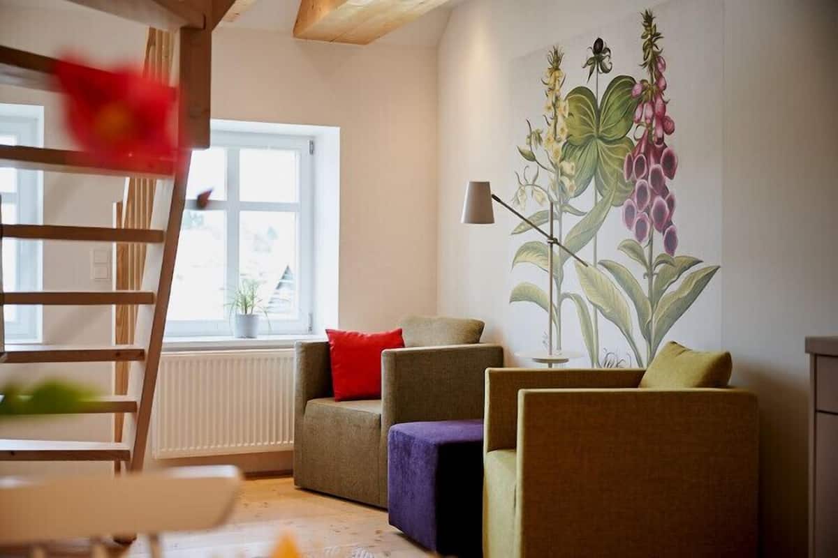 Een woonkamer met een bank, een stoel, een klein tafeltje en een raam met uitzicht.