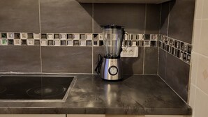 A kitchen with a built-in stove, a blender, and a white oven. - Gilmore Home - close to Paris center (La Courneuve)