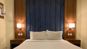 Ein Hotelzimmer mit einem großen Bett, zwei Nachttischen und einem hölzernen Kopfteil.