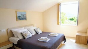Ein Schlafzimmer mit Bett, Kissen, Nachttisch und einem Bild an der Wand.