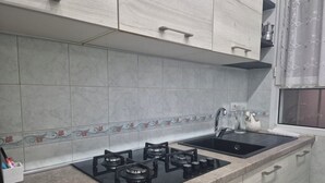 A kitchen with a gas stove, sink, and cabinets. - ALEX B&B (Rome)