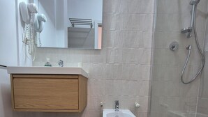 A modern bathroom with a wooden vanity, a pedestal sink, and a glass-enclosed shower. - ALEX B&B (Rome)