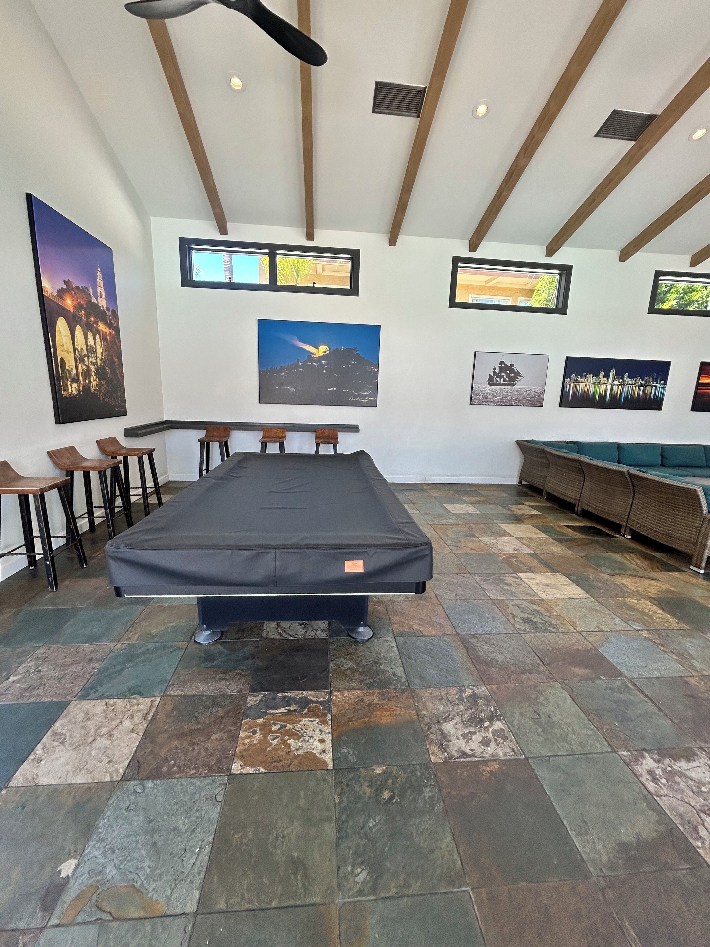 Een kamer met een groot bed, een slaapbank, een eethoek met stoelen en kunst aan de muren.