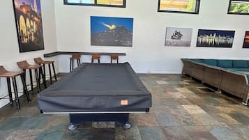 Ein Zimmer mit einem großen Bett, einem Sofa, einem Essbereich mit Stühlen und Kunstwerken an den Wänden.