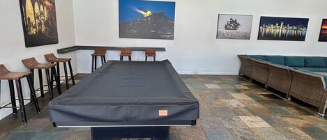 Een kamer met een groot bed, een slaapbank, een eethoek met stoelen en kunst aan de muren.