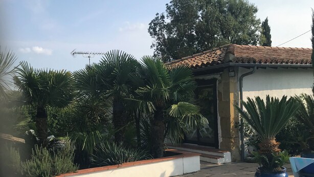 A swimming pool surrounded by lush greenery and a tiled-roofed building. - Gîte with swimming pool in the Gers, 45 minutes from Toulouse.  (Gimont)
