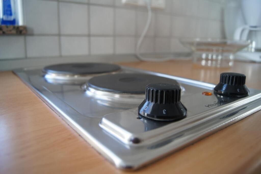 A kitchen with a stainless steel stove and two knobs.