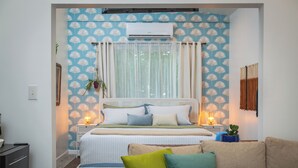 Une chambre à coucher avec un lit, des tables de chevet, une commode et une fenêtre avec des rideaux.