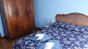 A bedroom with a bed, a wardrobe, and a nightstand. - Cozy apartment a stone's throw from the historic center of Rome (Roma)