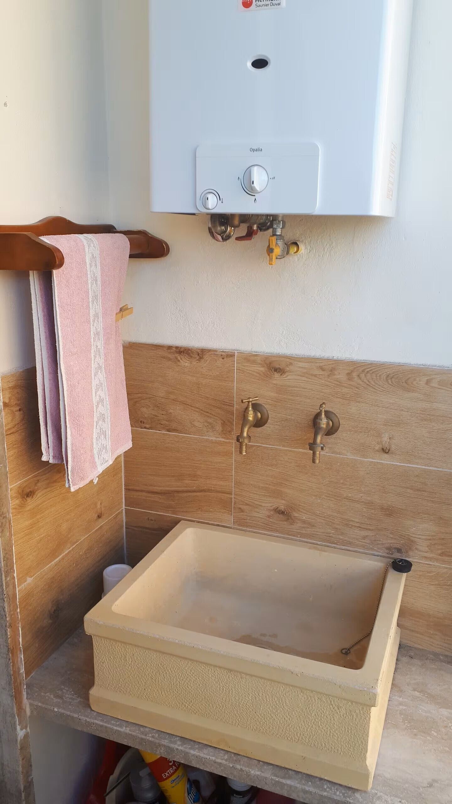 A bathroom with a wooden vanity, a sink, and a towel rack.