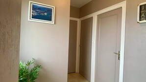 A hallway with beige walls, a light fixture, a framed picture, and a door. - L'étape conviviale gîte 2 for 6 people (Guitté)