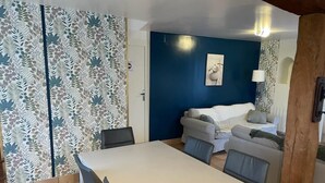 Une pièce comprenant une table à manger, des chaises, un canapé et un lit.