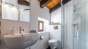 Ein Badezimmer mit einem großen Waschbecken, Toilette und Dusche.