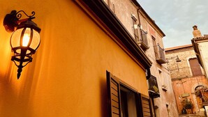 Eine enge Straße mit einem gelben Gebäude, einer schwarzen Markise und einer traditionellen Laterne.