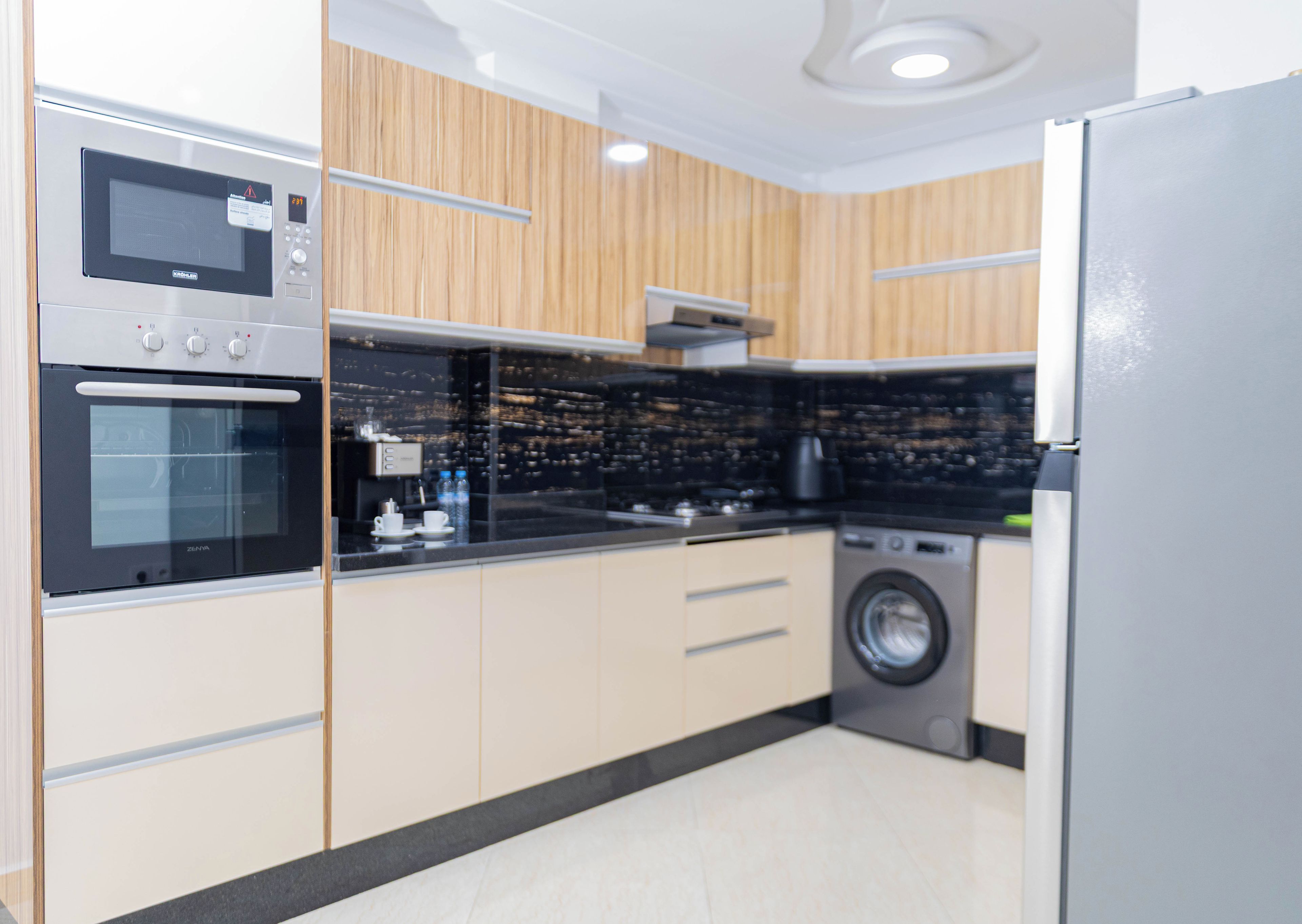 A modern kitchen with built-in appliances, including a microwave, oven, and washing machine.