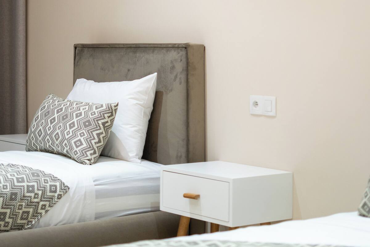 Une chambre d’hôtel comprenant un lit, une table de chevet et une œuvre d’art accrochée au mur.