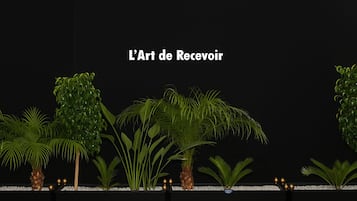 Un área de recepción con varias plantas y un logotipo en el suelo.