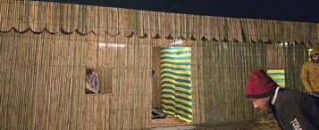 A bamboo structure with a window and a striped curtain.