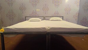 Een eenpersoonsbed met witte beddengoed in een kamer met behang met patroon.