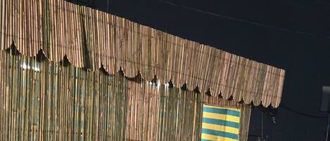 A corrugated metal building with a striped door and a window.
