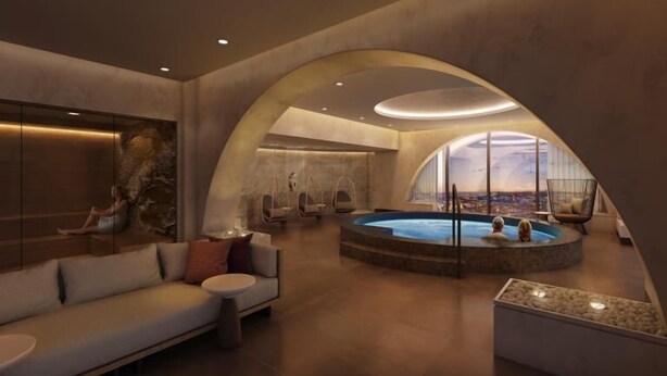 A modern spa with a circular hot tub, a sofa, and a view of the city. - Wind Creek Southland Casino and Hotel (Hazel Crest)