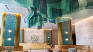 A modern lobby with a central reception desk, seating areas, and decorative lighting. - Wind Creek Southland Casino and Hotel (Hazel Crest)