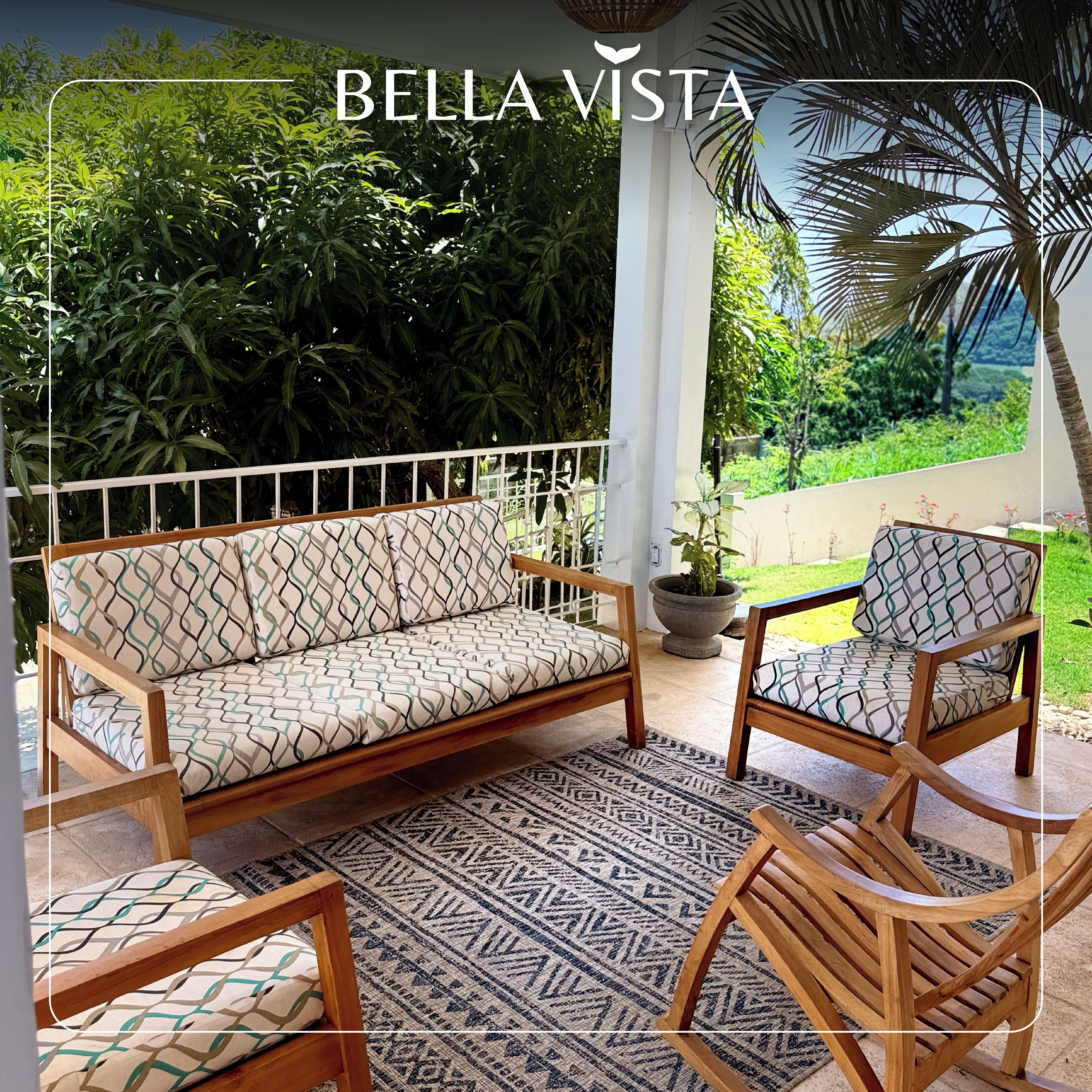 Eine Terrasse mit einer Couch, zwei Stühlen, einem gemusterten Teppich und einem Blumentopf.