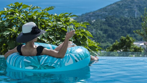 A person in a pool with a view of the sea and hills. - Nedia Retreat - Private Pool & Stunning Sea View (Mlini)