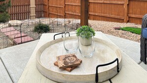 A round table with a glass top, a small potted plant, and a coaster. - BarknBike Abode Pets Bikes Desk Garage (Fruita)