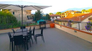 A terrace with outdoor seating, a table, and a grill. - 07. Apartment (Signa)