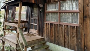 Eine rustikale Holzhütte mit Veranda und Stufen zum Eingang.