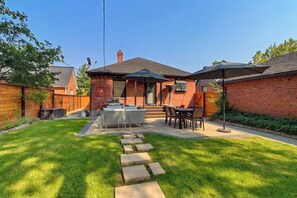 Enjoy al fresco dining on the patio, surrounded by a beautifully manicured lawn and equipped with a grill and comfortable seating.