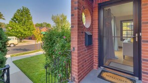 A brick exterior with a glass door and a welcome mat. - NEW Old Southwest Gem, Patio, Grill, Smart TV, 2 Desks + Fitness Equipment

 (Reno)