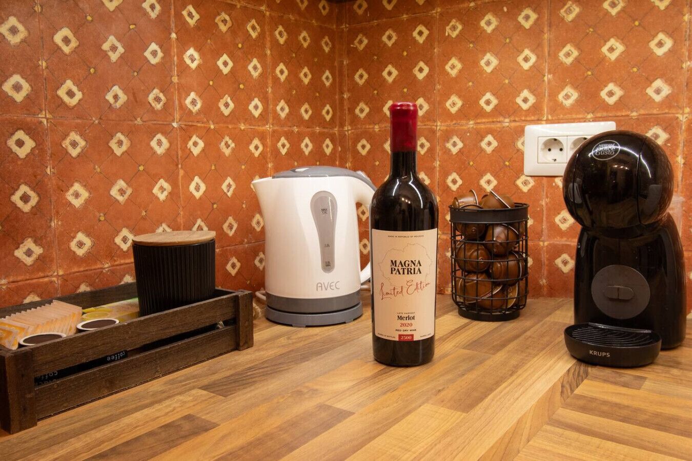 Une cuisine équipée d’une bouteille de vin, d’une machine à café et d’une bouilloire.