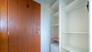A wooden door with the number 3, adjacent to a white shelving unit with multiple compartments.