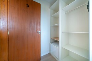 A wooden door with the number 3, adjacent to a white shelving unit with multiple compartments.