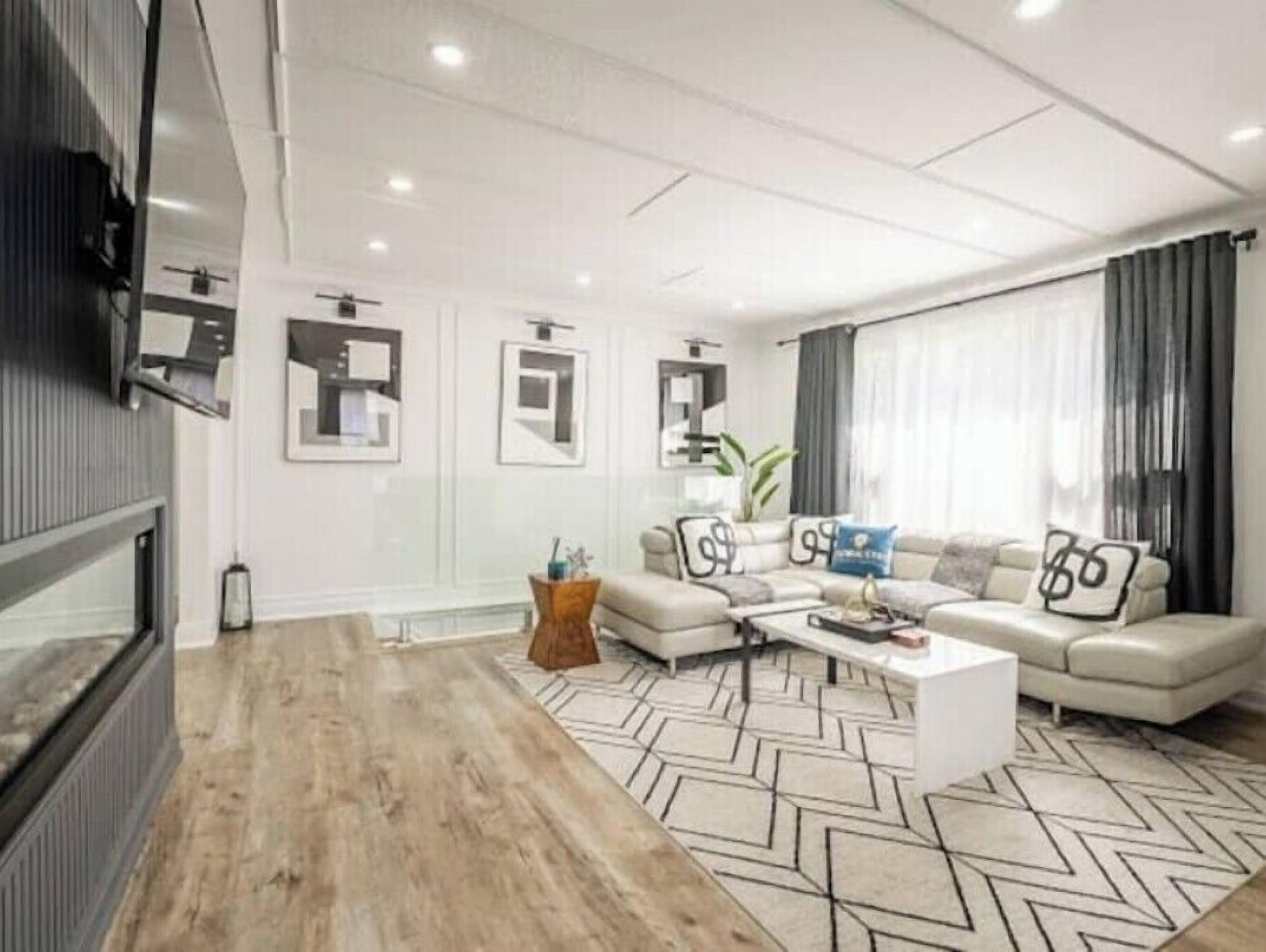 Un saló modern amb un sofà, una taula de centre i coixins decoratius.
