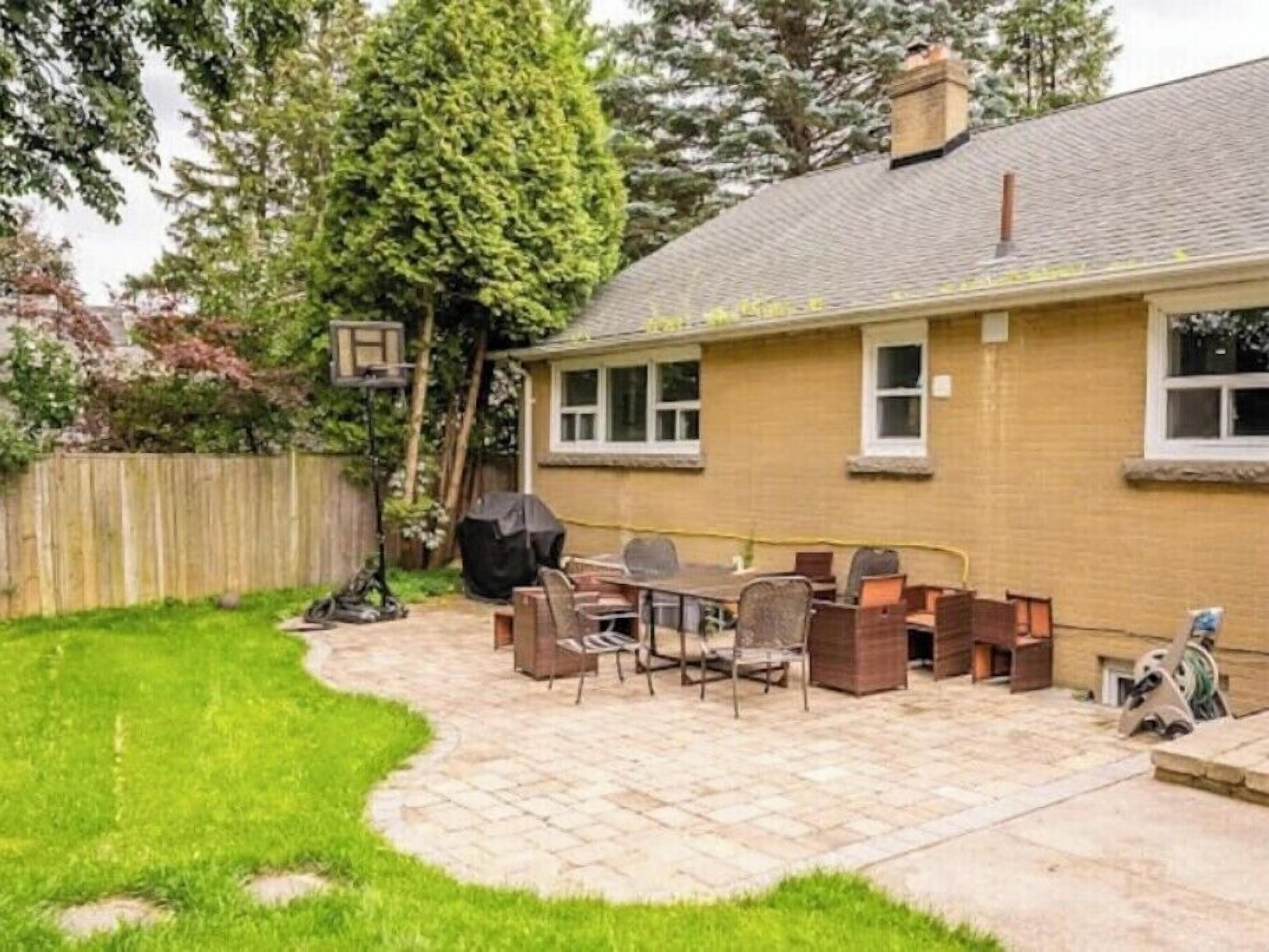 Un patio trasero con un porche, una parrilla y muebles de exterior.