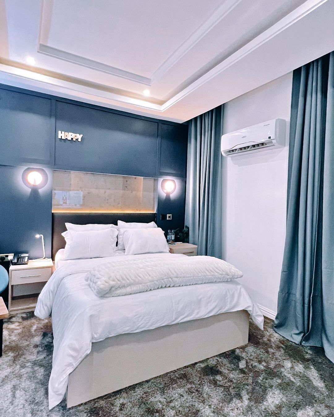 Et moderne hotelværelse med en stor seng, sengeborde, et skrivebord og en aircondition.